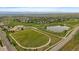 Aerial view showcasing a community with green spaces, a school, a pond, and roads at 1181 W 170Th Ave, Broomfield, CO 80023