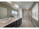 Bright bathroom featuring a double sink vanity, large mirror, and glass-enclosed shower at 1181 W 170Th Ave, Broomfield, CO 80023