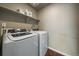 Efficient laundry room with modern washer and dryer, and overhead shelving at 1181 W 170Th Ave, Broomfield, CO 80023