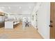 Bright, open-concept living space features a kitchen island with bar seating, a dining area, and hardwood floors at 2505 Upham St, Lakewood, CO 80214