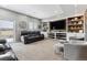 Finished basement with a large screen television, built-in shelves, and comfortable seating at 7301 S Shady Grove Way, Aurora, CO 80016