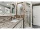 Bathroom with granite counters, updated shower with custom tile work, and decorative fixtures at 7301 S Shady Grove Way, Aurora, CO 80016