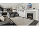 Spacious living room featuring a fireplace with a stone surround and an open floorplan into the kitchen at 7301 S Shady Grove Way, Aurora, CO 80016