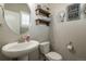 Charming powder room with a pedestal sink, oval mirror and modern fixtures at 7301 S Shady Grove Way, Aurora, CO 80016
