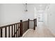 Bright hallway with wood floors, elegant chandelier, and staircase with wood railing at 6966 E 126Th Pl, Thornton, CO 80602