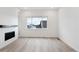 Bright living room featuring a modern fireplace and large window with neighborhood views at 6966 E 126Th Pl, Thornton, CO 80602