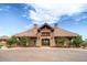 Stone clubhouse exterior featuring well-manicured grounds and porte-cochere entry at 7258 Oasis Dr, Castle Rock, CO 80108