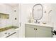 Modern bathroom features a glass shower and vanity with green cabinets and black hardware at 2773 S Garfield St, Denver, CO 80210