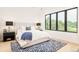 Sunlit bedroom features a large window, plush rug, and stylish lamps on the bedside tables at 2773 S Garfield St, Denver, CO 80210