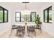 Bright dining room with stylish lighting fixture, table and chairs, and a view of the outdoors through large windows at 2773 S Garfield St, Denver, CO 80210