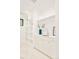 Bright laundry room with white cabinetry, marble tile floors, shelving, and natural light at 2773 S Garfield St, Denver, CO 80210