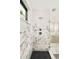 Elegant shower with marble walls, rain shower head, and black honeycomb floor tiles at 2773 S Garfield St, Denver, CO 80210