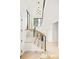 Grand staircase with modern railing, natural wood steps, contemporary light fixture, and bright natural light at 2773 S Garfield St, Denver, CO 80210