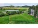 Aerial view of the property showcasing a large green lot with a pond, surrounded by trees and mountain vistas at 7614 Malamute Dr, Evergreen, CO 80439