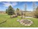 Backyard fire pit area with stocked woodpile and a small creek adding a rustic charm to the landscape at 7614 Malamute Dr, Evergreen, CO 80439