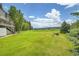 Expansive green backyard featuring a fire pit and stunning views of distant mountains under a bright blue sky at 7614 Malamute Dr, Evergreen, CO 80439