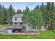 Backyard with a wooden deck, mature trees, and a well-maintained lawn, perfect for outdoor gatherings at 7614 Malamute Dr, Evergreen, CO 80439