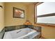 Inviting bathtub with tiled surround, perfect for unwinding and relaxing after a long day at 7614 Malamute Dr, Evergreen, CO 80439