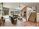 Bright open concept living room, fireplace, large windows, with easy access to the staircase at 7614 Malamute Dr, Evergreen, CO 80439