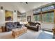 Bright living room featuring large windows, comfortable sofas, and rustic accents, creating a warm and inviting space at 7614 Malamute Dr, Evergreen, CO 80439