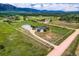 Aerial view of estate featuring sprawling land, main house, detached outbuilding, and surrounding countryside at 16710 Vincent Ave, Monument, CO 80132