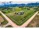 An elevated view of a home, showing its large fenced property, with rolling hills and mountain views in the distance at 16710 Vincent Ave, Monument, CO 80132