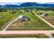 Expansive property with a modern home, detached garage, and white fencing against a mountain backdrop at 16710 Vincent Ave, Monument, CO 80132
