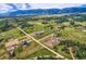A bird's eye view shows this property's setting amidst rolling green hills and scattered neighboring houses at 16710 Vincent Ave, Monument, CO 80132