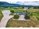 Stunning aerial view of a home with a large garage, and mountain views with rolling hills and scattered homes in the background at 16710 Vincent Ave, Monument, CO 80132