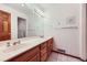 Bathroom featuring double sinks, attractive wood cabinetry, and an oversized mirror at 16710 Vincent Ave, Monument, CO 80132