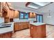 Well-lit kitchen with wooden cabinets, an island, tile countertops, and stainless steel appliances at 16710 Vincent Ave, Monument, CO 80132