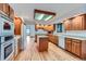 Spacious kitchen featuring wooden cabinets, an island, hardwood floors, and modern appliances, offering a blend of style and functionality at 16710 Vincent Ave, Monument, CO 80132