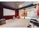 Spacious theater room with projector screen, comfortable seating, and adjacent bar area at 16710 Vincent Ave, Monument, CO 80132