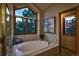 Bright bathroom features soaking tub with marble surround and scenic window view at 386 Monte Vista Rd, Golden, CO 80401
