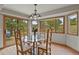 Dining room features hardwood floors, a modern chandelier, and a table surrounded by windows showcasing nature views at 386 Monte Vista Rd, Golden, CO 80401