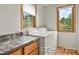 Laundry room features oak cabinets, granite countertop, and a window at 386 Monte Vista Rd, Golden, CO 80401