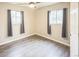 Cozy bedroom features neutral walls, wood-look flooring, two windows with modern curtains, and a ceiling fan at 6104 Hudson St, Commerce City, CO 80022