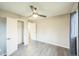 Bedroom featuring a ceiling fan, neutral walls, wood-look flooring, closet, and a window with curtains at 6104 Hudson St, Commerce City, CO 80022