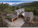 Aerial image showcases a mountain home with a long driveway, attached two-car garage, and beautiful mountain view at 1055 Divide View Dr, Golden, CO 80403