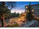 A backyard view, showing a stone landscape design, fire pit and outdoor seating and home exterior at 1055 Divide View Dr, Golden, CO 80403