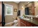 Cozy bathroom featuring granite countertops, wood cabinets, and a shower with stone accents at 1055 Divide View Dr, Golden, CO 80403