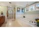 Bright bathroom featuring a soaking tub, wainscotting, and neutral tile floors at 1055 Divide View Dr, Golden, CO 80403