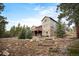 Exterior of home featuring lush green landscaping and views of surrounding mature trees at 1055 Divide View Dr, Golden, CO 80403