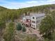 Stunning mountain home featuring a large deck and beautiful landscaping surrounded by a dense forest at 1055 Divide View Dr, Golden, CO 80403