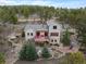 An elevated view of a mountain home with a large deck, stone landscaping, and forest surroundings at 1055 Divide View Dr, Golden, CO 80403