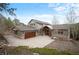 Stunning exterior showcasing a gray home, wood accents, a long driveway, and natural landscaping at 1055 Divide View Dr, Golden, CO 80403
