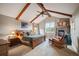 Inviting main bedroom with exposed beams, a stone fireplace, and ample natural light creating a retreat at 1055 Divide View Dr, Golden, CO 80403