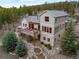 Beautiful home's rear exterior with a spacious deck, stone accents, and landscaped surroundings at 1055 Divide View Dr, Golden, CO 80403