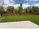 Expansive backyard featuring a green lawn, mature trees, and a wood fence at 7054 Welch Ct, Arvada, CO 80004