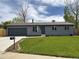 Charming single-story home with a well-maintained lawn, gray exterior, and an attached garage with a new driveway at 7054 Welch Ct, Arvada, CO 80004